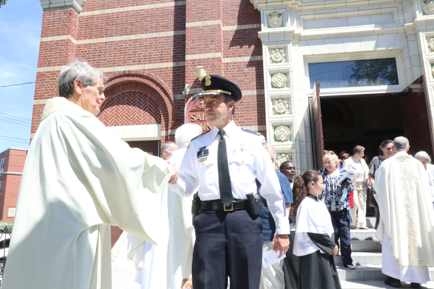 Providence Police Chief Hugh Clements greets Father David Ricard, chaplain at Kent County Hospital for more than 40 years, complimenting him on his homily after the Mass of Thanksgiving.